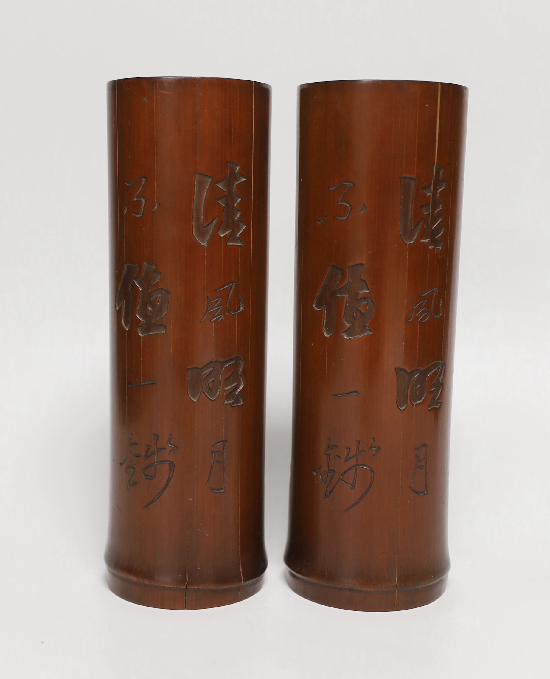 A pair of Chinese bamboo brushpots carved with figures and junks, each 22cm high